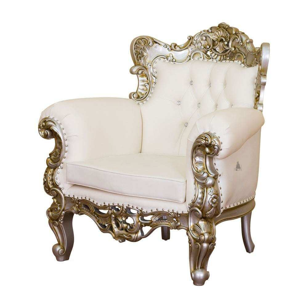 The Aphrodite Parlour Chair, a handcrafted ornate upholstered chair with rolled arms, carved crest and buttoned back.