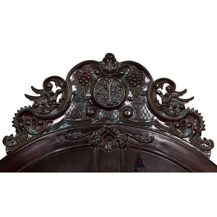 Angled view of the Aurora Bed showing raised semi-canopy structure, shaped headboard and decorative carving