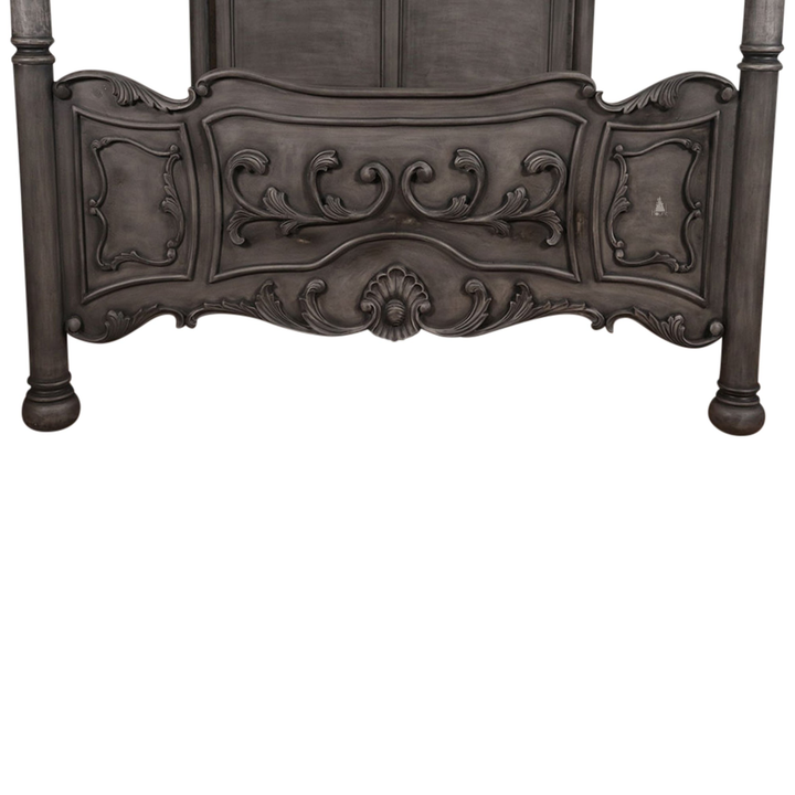 The Countess Bed, a handcrafted four poster bed with slender posts, a shaped panel headboard and an ornate scrolled footboard.