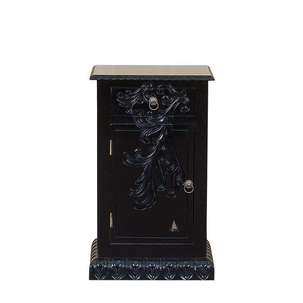 The Dark Desires Side Table, a handcrafted black gothic bedside cabinet with carved front detailing, ring-pull hardware and a heavy plinth base.