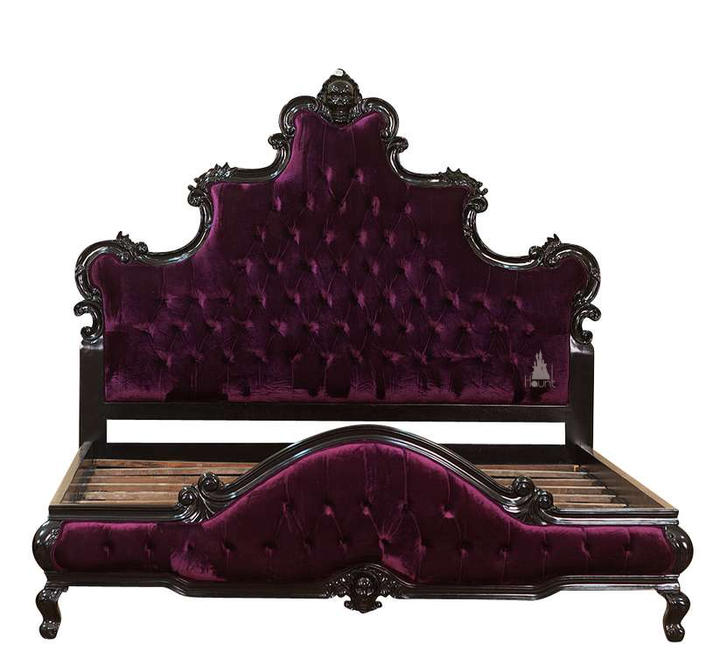 The Death Aphrodite Bed, a handcrafted upholstered gothic bed with a tall shaped headboard, curved footboard and a carved skull crest.