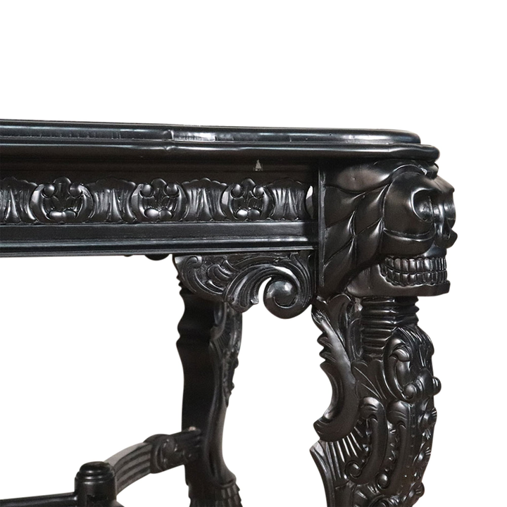 The Death Emperor Dining Table, a handcrafted black gothic dining table with carved legs, stretcher supports and skull detailing.