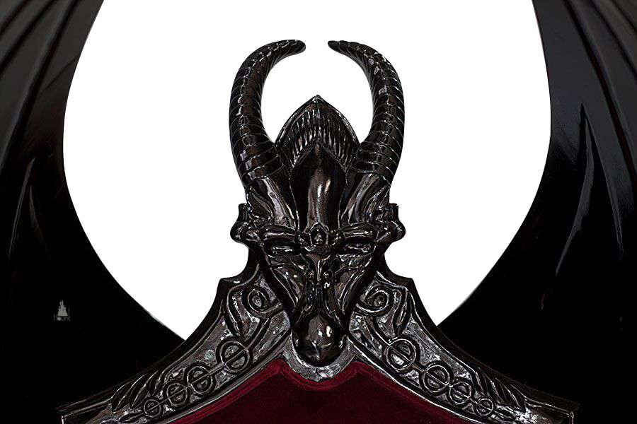 The House of Fire Throne, a handcrafted gothic throne chair with a bat-wing frame, horned carved crest and shield-shaped upholstered back.