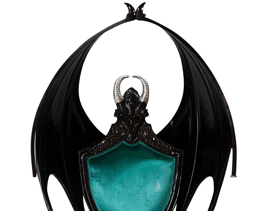 The House of Fire Throne, a handcrafted gothic throne chair with a bat-wing frame, horned carved crest and shield-shaped upholstered back.