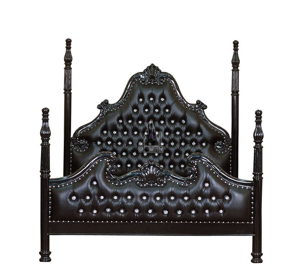 Front view of the Luxe Bed showing tall carved four poster posts, deep button-tufted upholstery and a hand-carved mahogany frame