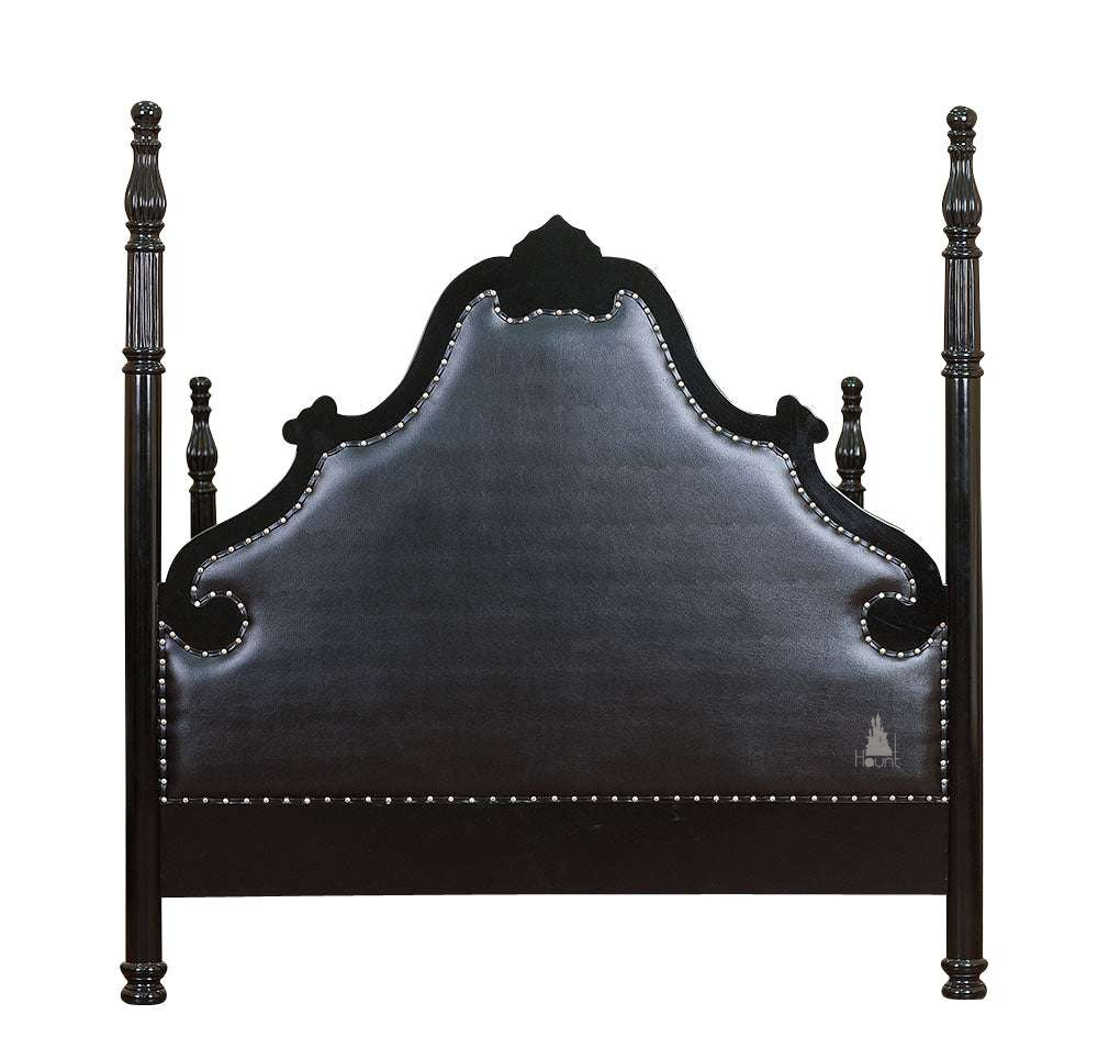 Luxe Bed headboard view showing black button-tufted upholstery, carved crest and tall mahogany posts