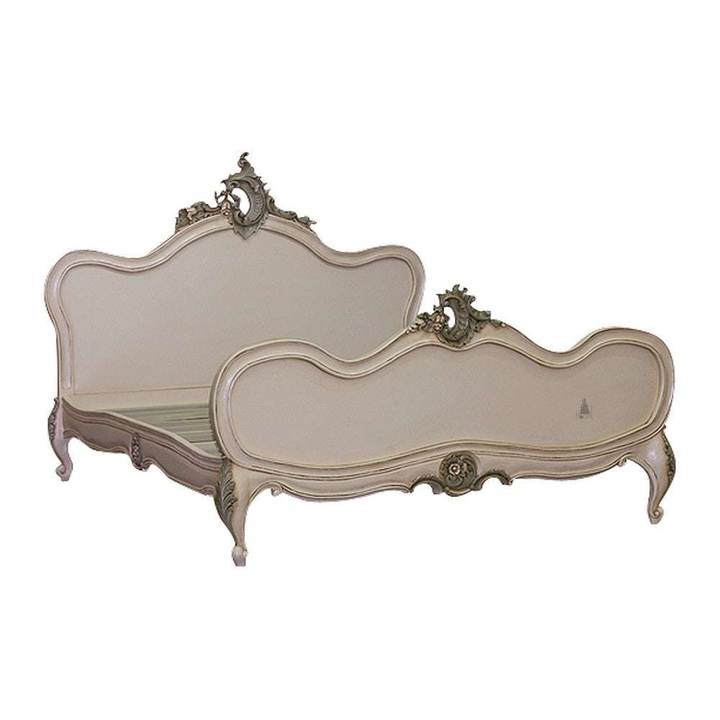 The Maleficent Bed, a handcrafted French provincial-style bed with a shaped headboard, low footboard and carved crest details.