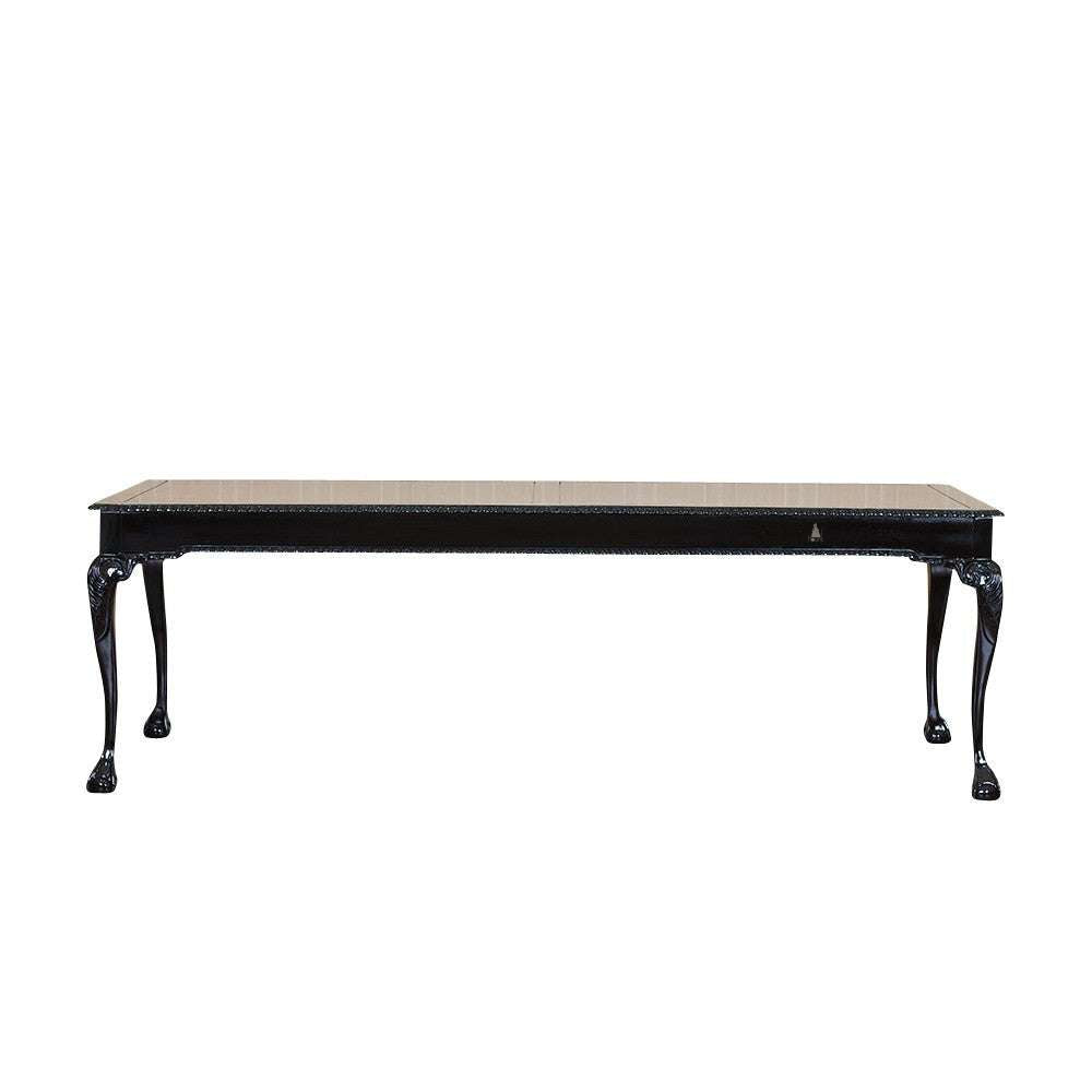 The Maleficent Dining Table, a handcrafted black dining table with a rectangular top and slender carved legs.
