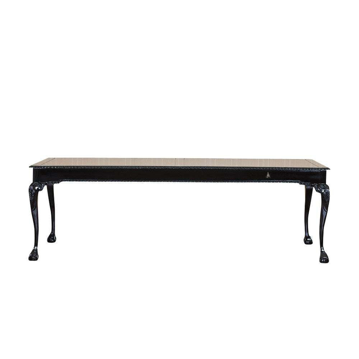 The Maleficent Dining Table, a handcrafted black dining table with a rectangular top and slender carved legs.