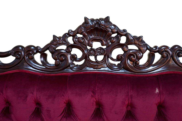 The Maleficent Lounge, a handcrafted gothic provincial sofa with deep button tufting, rolled arms and ornate carved timber frame.