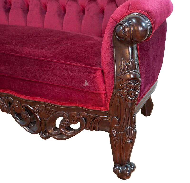 The Maleficent Lounge, a handcrafted gothic provincial sofa with deep button tufting, rolled arms and ornate carved timber frame.