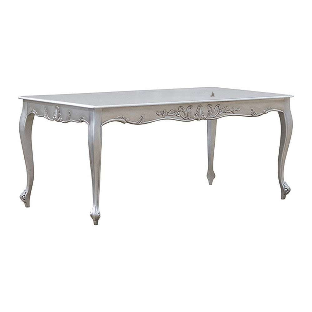 The Poseidon Dining Table, a handcrafted pale-toned dining table with a flowing carved apron and elegant cabriole legs.