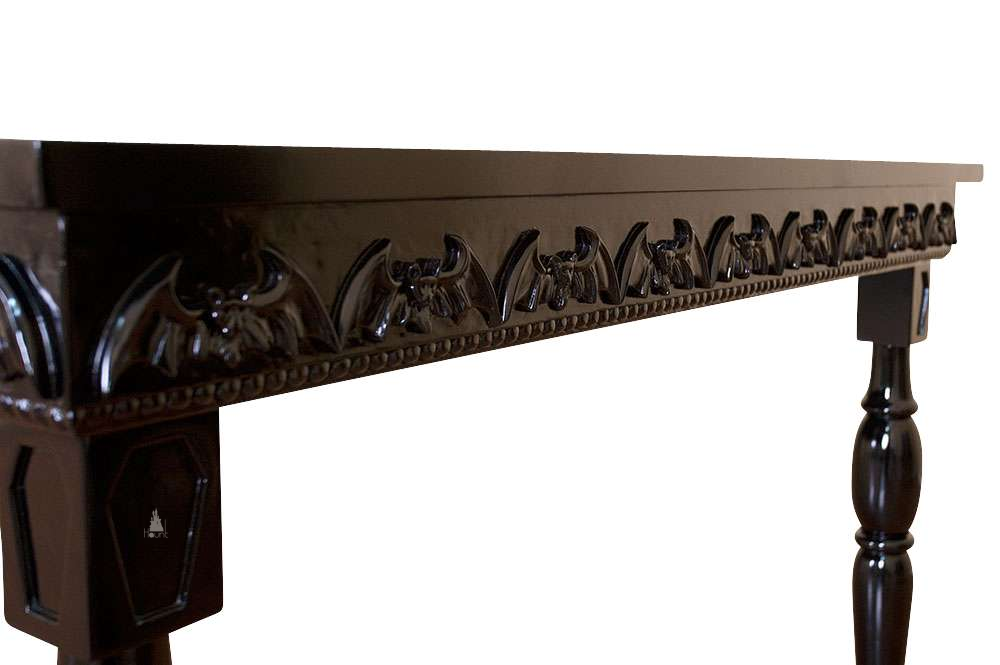 The Queen of the Damned Dining Table, a handcrafted gothic dining table with carved supports and raised bat detailing along the apron.