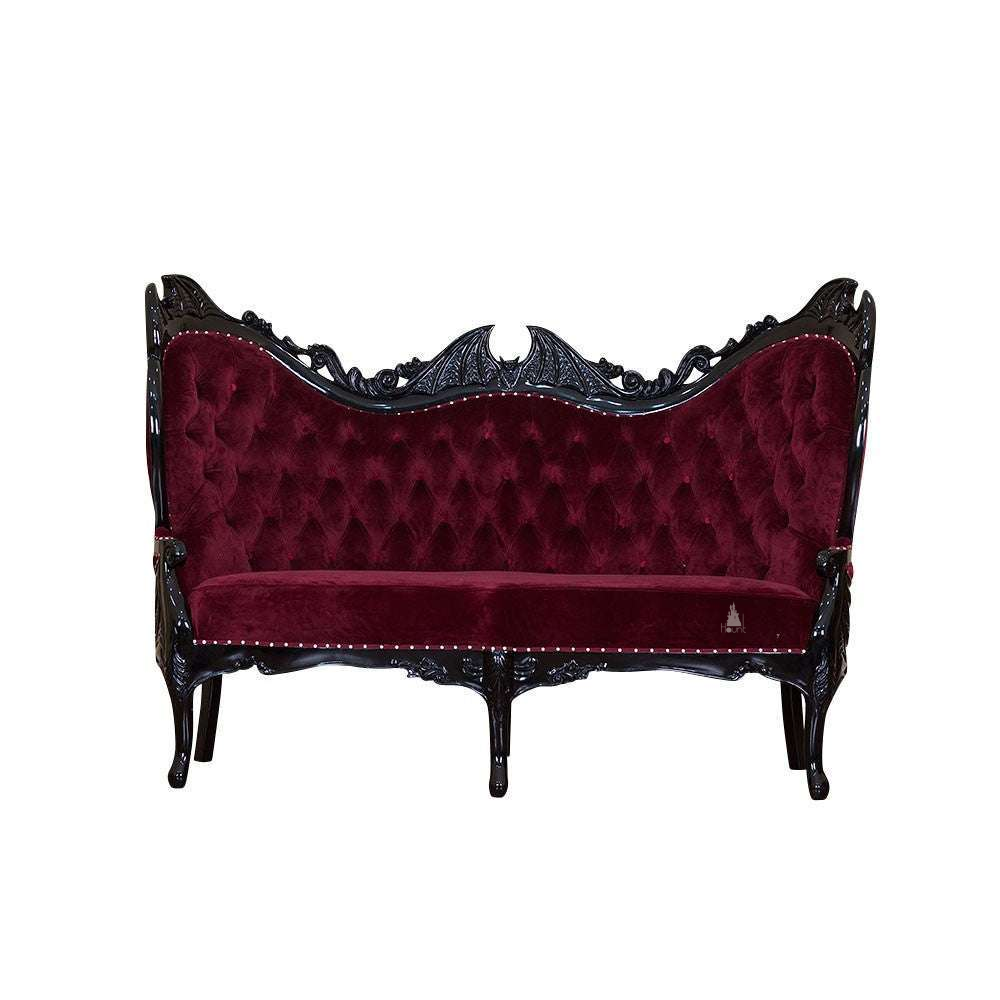 Queen of the Damned Love Seat, a dramatic two-seat gothic sofa with deep red upholstery, a black carved frame and a bat-wing crest at the centre of the back