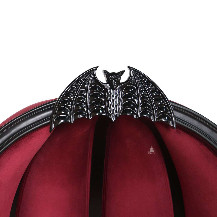 Another view of the Queen of the Damned Porter Chair, a tall hooded chair with deep red upholstery and a bat crest