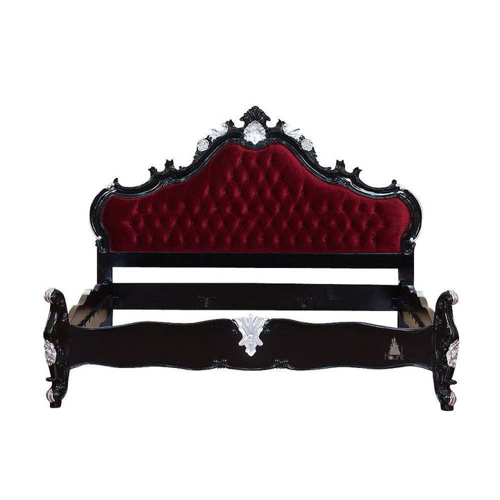 The Vampiress Bed, a handcrafted upholstered bed with a tall serpentine headboard, deep button tufting and carved gothic detailing.