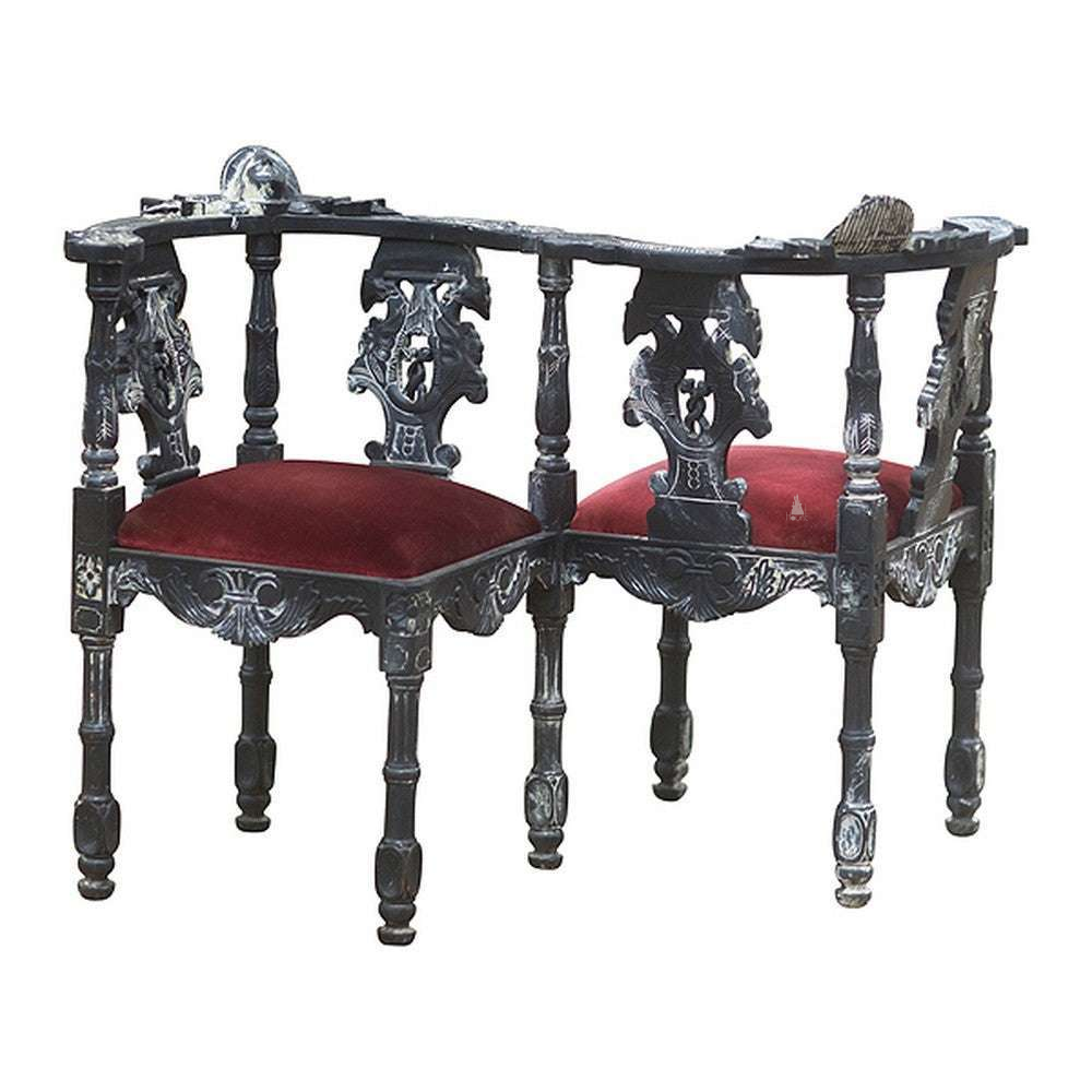 Vampiress Parlour Chair by Haunt Cult, a circular-style parlour chair made from connected black carved chair sections with red upholstered seats, turned legs and open carved backs