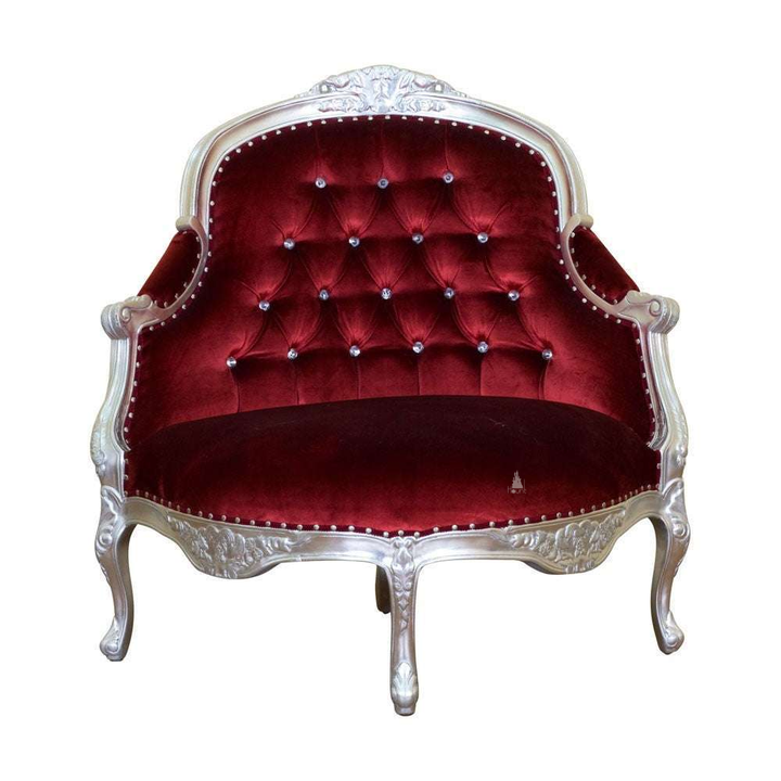 Vampiress Roundabout Parlour Chair by Haunt Cult, a curved red velvet parlour chair with a pale carved frame, button-tufted back, rounded arms, nailhead trim and cabriole legs